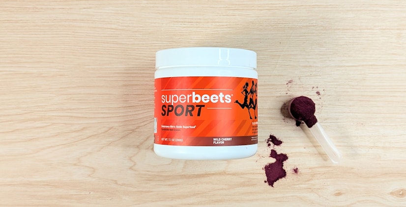 Bird’s-eye view of HumanN SuperBeets, with scoop, on a wood surface.