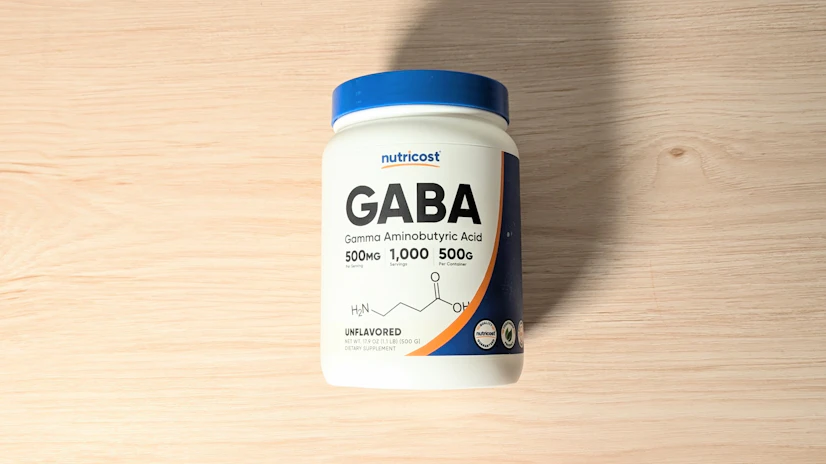 Nutricost GABA Powder on a wood surface.