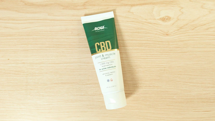 NOW Solutions CBD Joint & Muscle Cream on wood surface