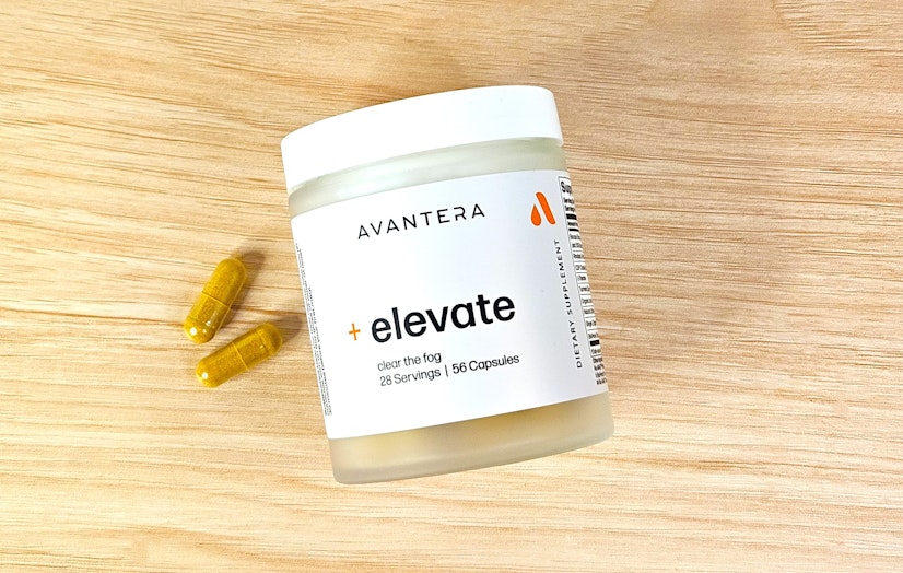 The Avantera Elevate jar and two capsules on a wooden background