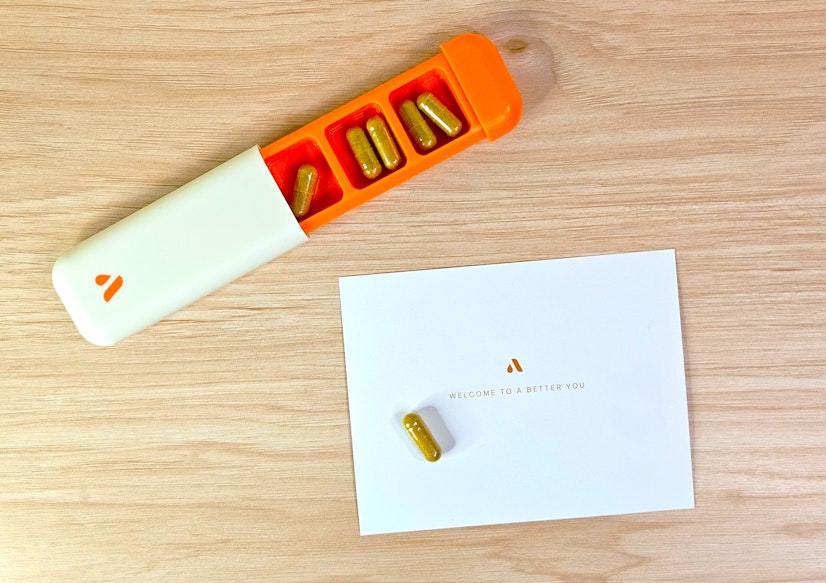 An Avantera postcard that reads “Welcome to a Better You” is placed next to the Avantera Elevate travel case filled with five capsules