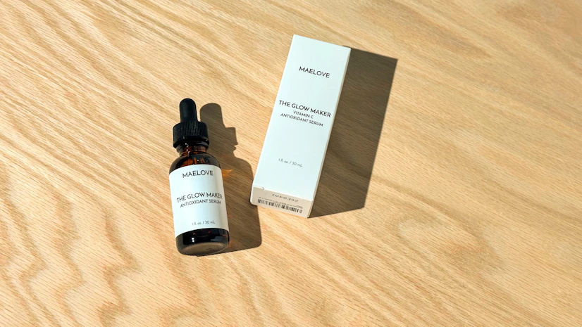 Overhead view of a Maelove Glow Maker Vitamin C Serum bottle on a tabletop with its box beside it
