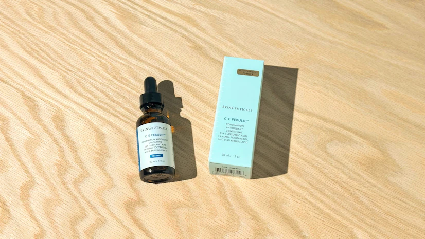 Overhead view of a SkinCeuticals C E Ferulic bottle on a tabletop with its box beside it