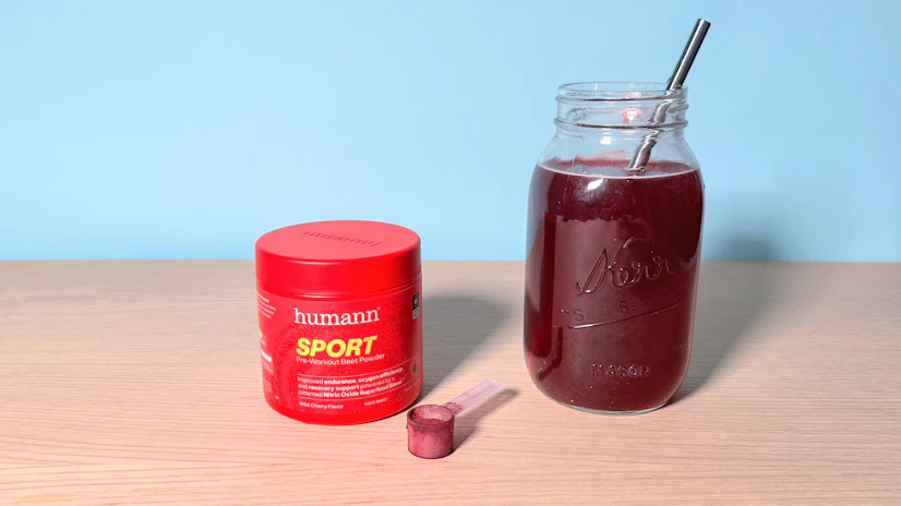 HumanN SPORT being stirred into water in a glass next to the tub it comes in.