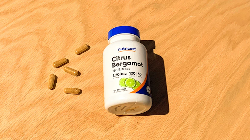 Overhead view of a Nutricost Citrus Bergamot bottle on a tabletop with capsules beside it
