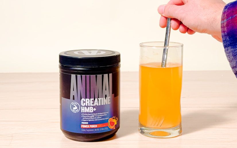 Animal Creatine HMB+ mixed into a glass next on a tan background