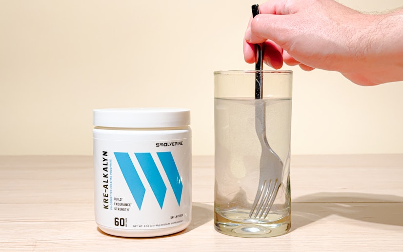 Swolverine Kre-Alkalyn mixed into a glass on a tan background