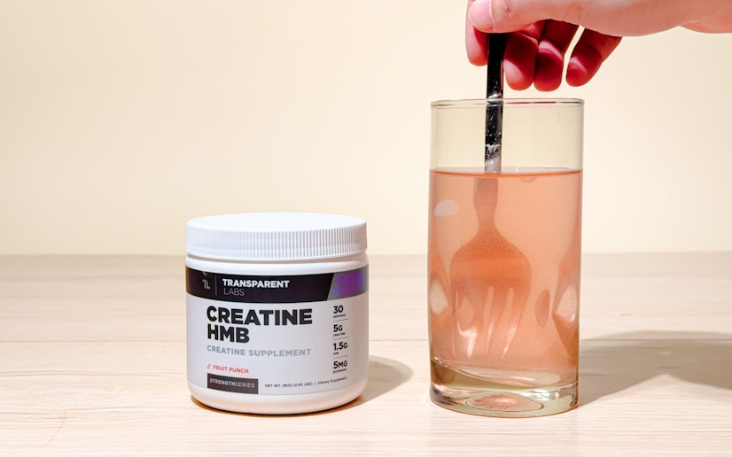 Transparent Labs Creatine HMB mixed into a glass on a tan background