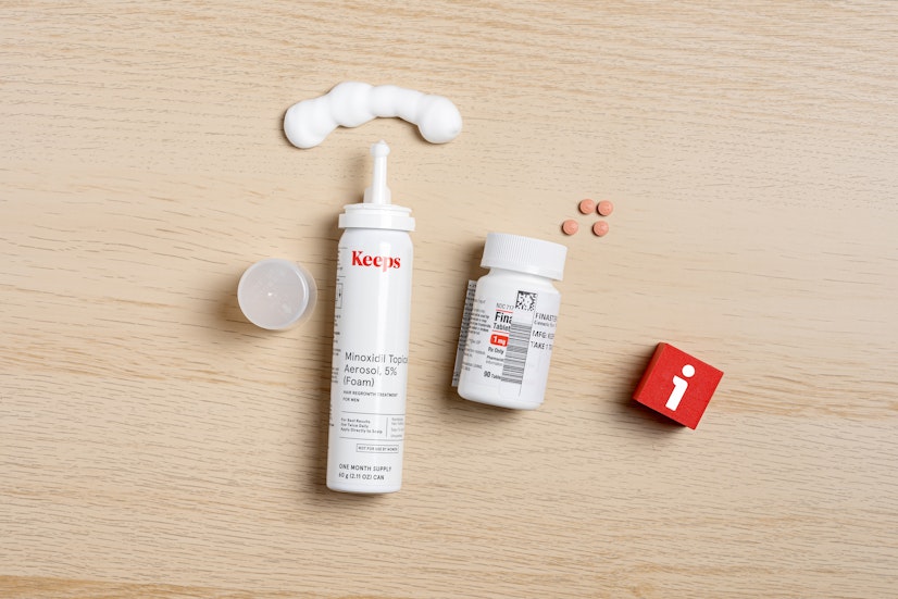 Keeps Minoxidil 5% foam and Finasteride 1mg tablets on wooden surface