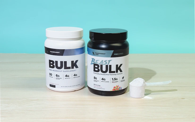 Transparent Labs Beast Bulk tub with a glass into which a hand is stirring the powdered supplement.