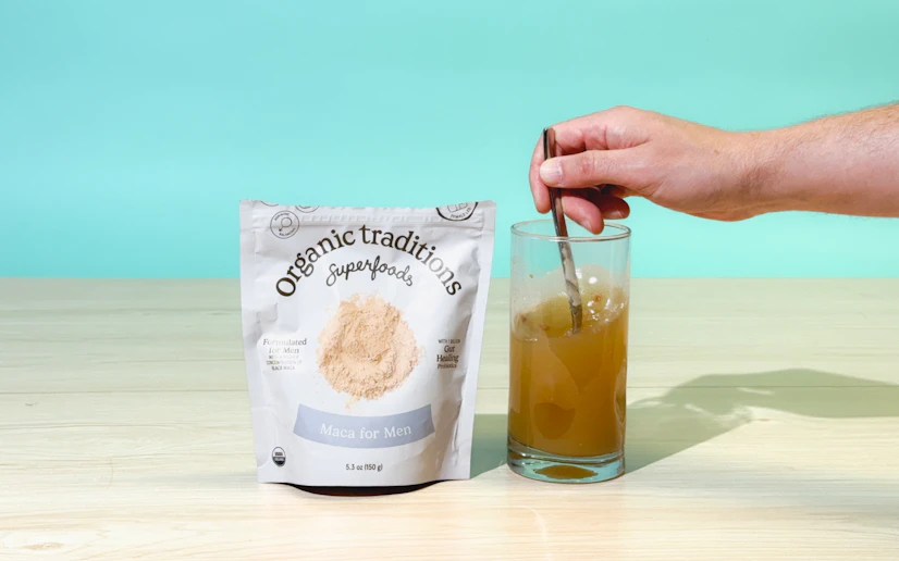 A picture of the Organic Traditions Maca bag with a glass being stirred