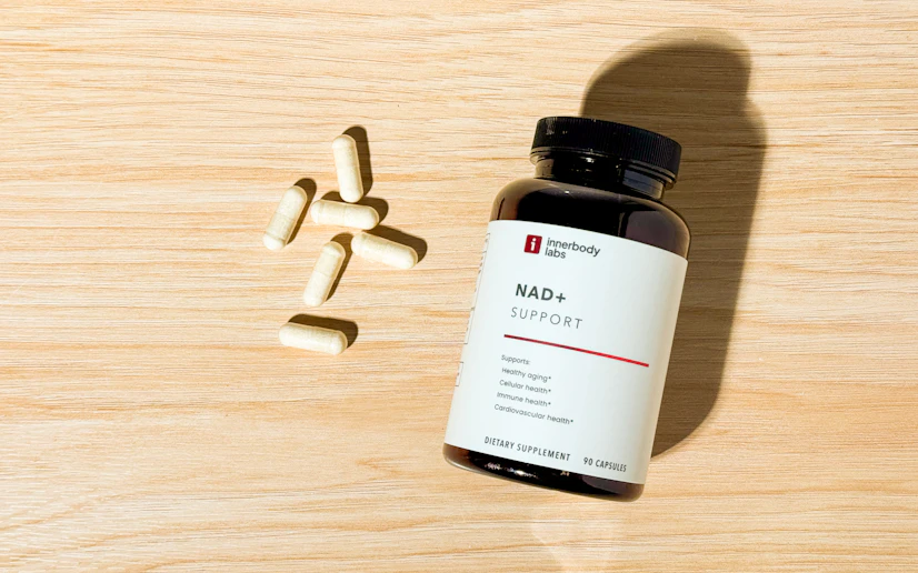 Innerbody Labs NAD+ Support bottle and capsules on a wood surface.
