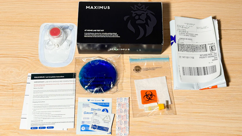 Various contents of a Maximus Tribe testing kit laid out on a wood surface