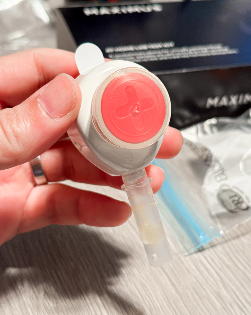 A closeup of the red and white Tasso+ blood-draw device