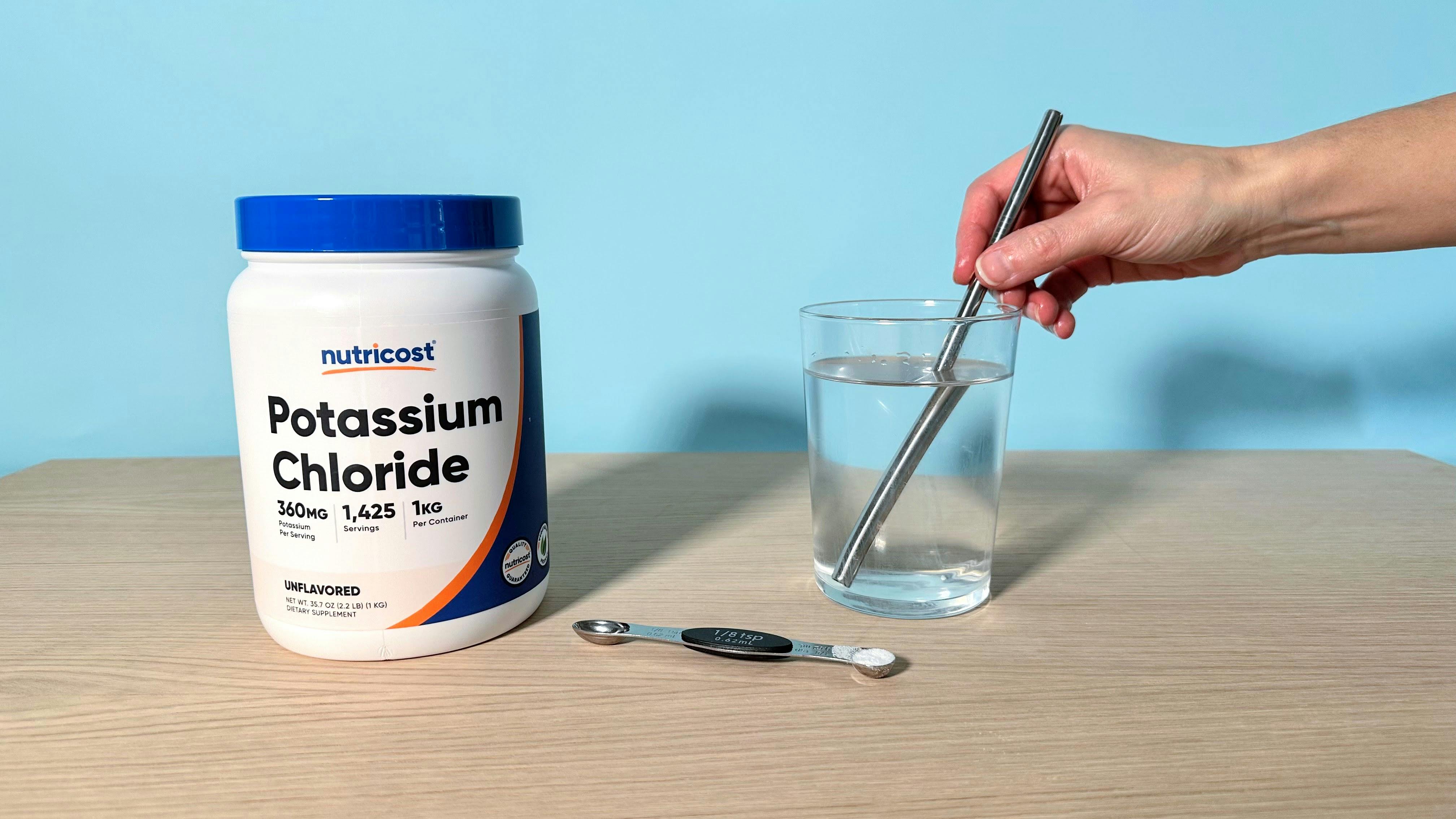 Nutricost Potassium Chloride container with glass and spoon preparing supplement powder