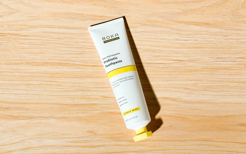 Tube of BOKA probiotic toothpaste lying on a wooden surface.
