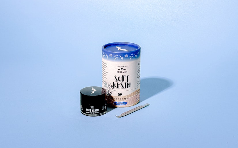 Pure Himalayan Shilajit Soft Resin with metal spoon on a blue background.