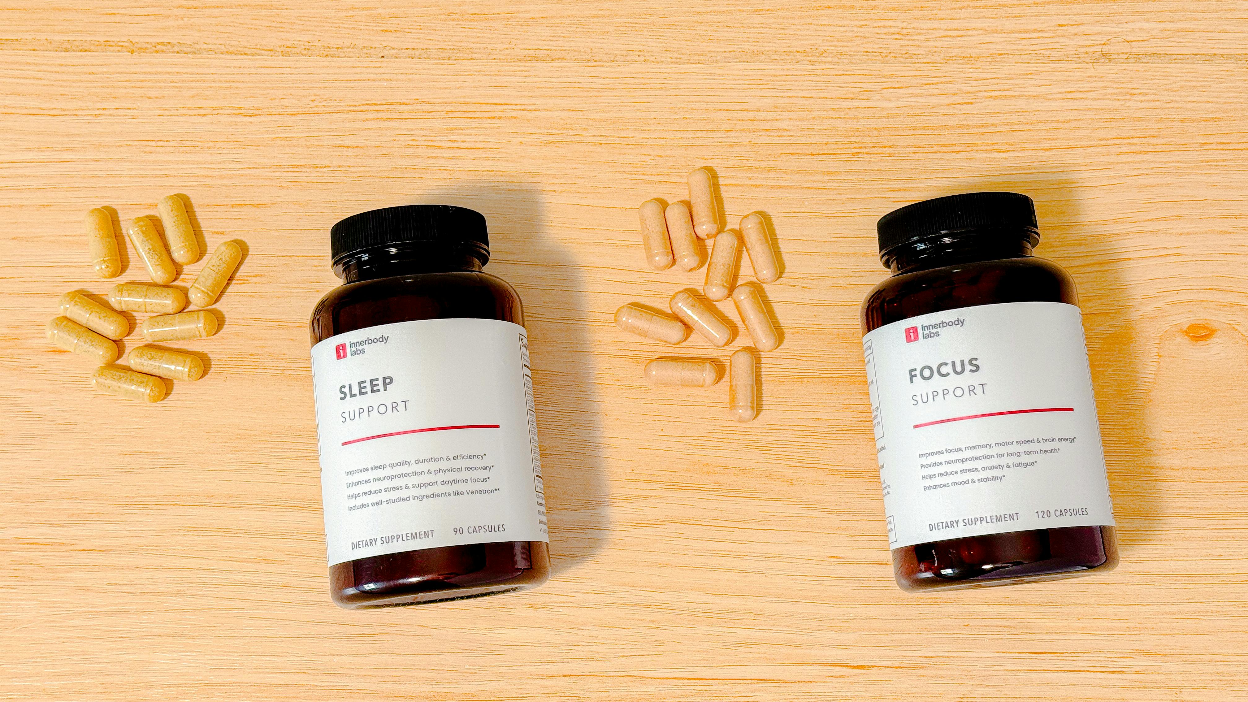 Sleep Support and Focus Support supplement bottles and capsules from above on a wood countertop