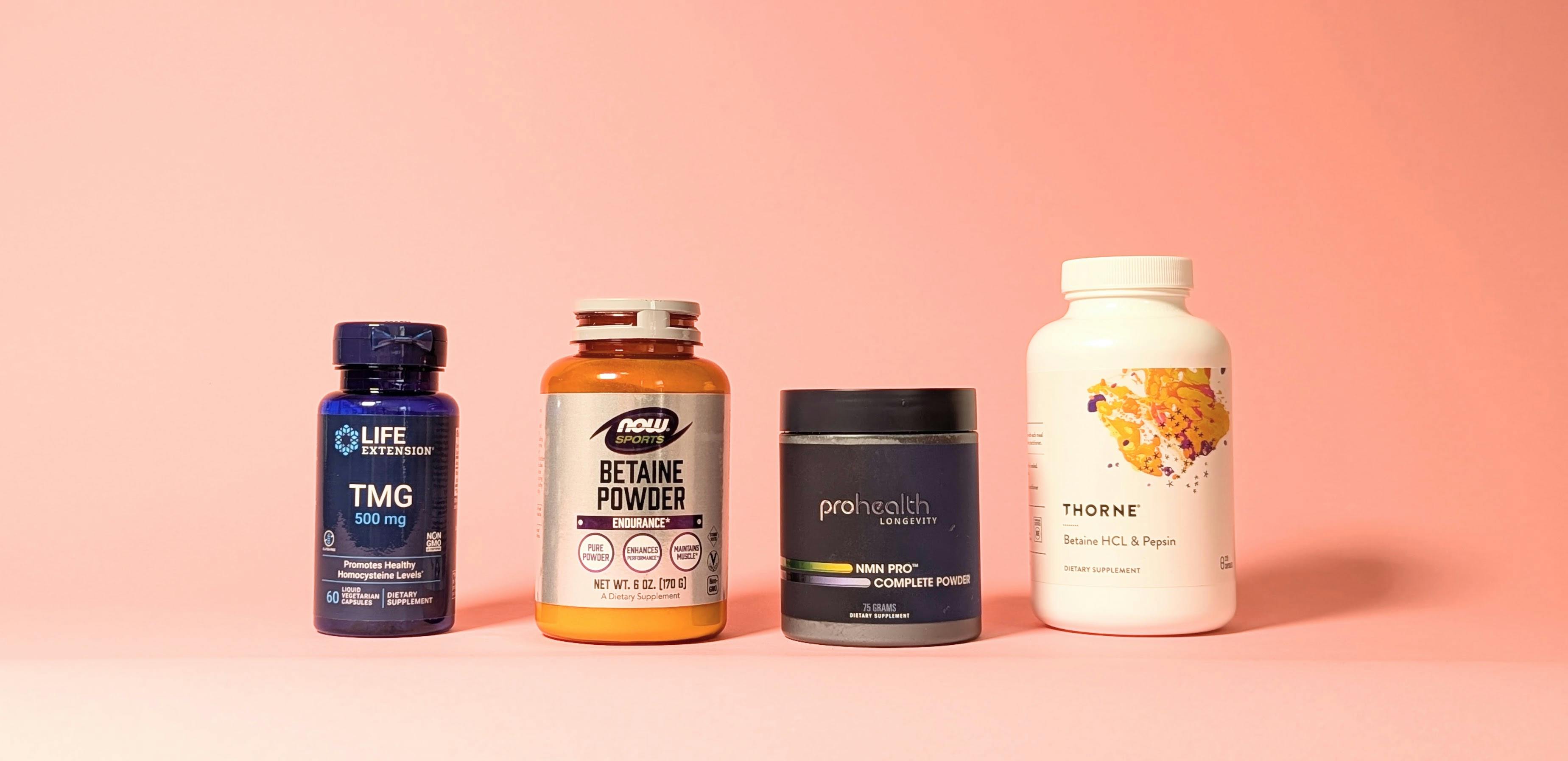 Four bottles and containers of TMG and related supplements arranged in a row