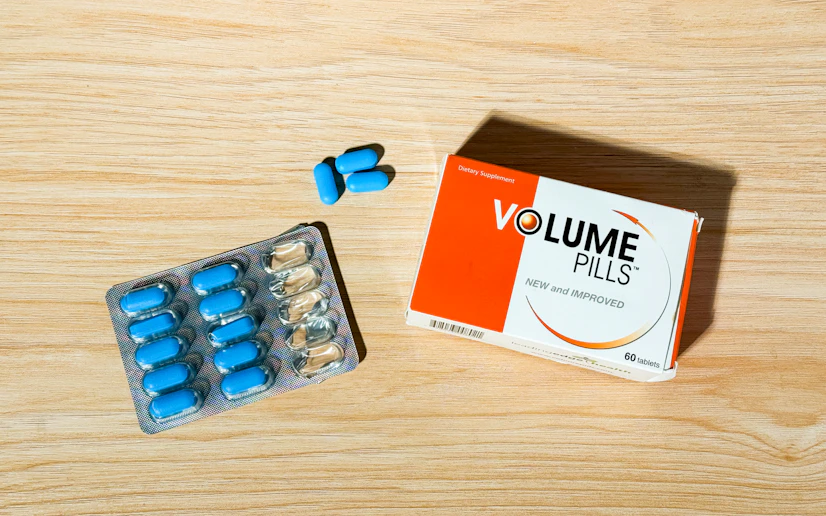 A box of Volume Pills with one of its blister pack sleeves opened next to it and laid out on a wood surface