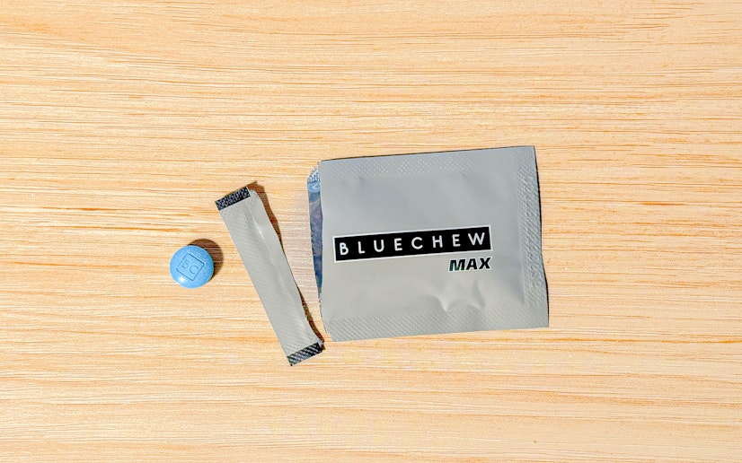 A single BlueChew MAX packet torn open and sitting on a wooden surface next to a chewable tablet.