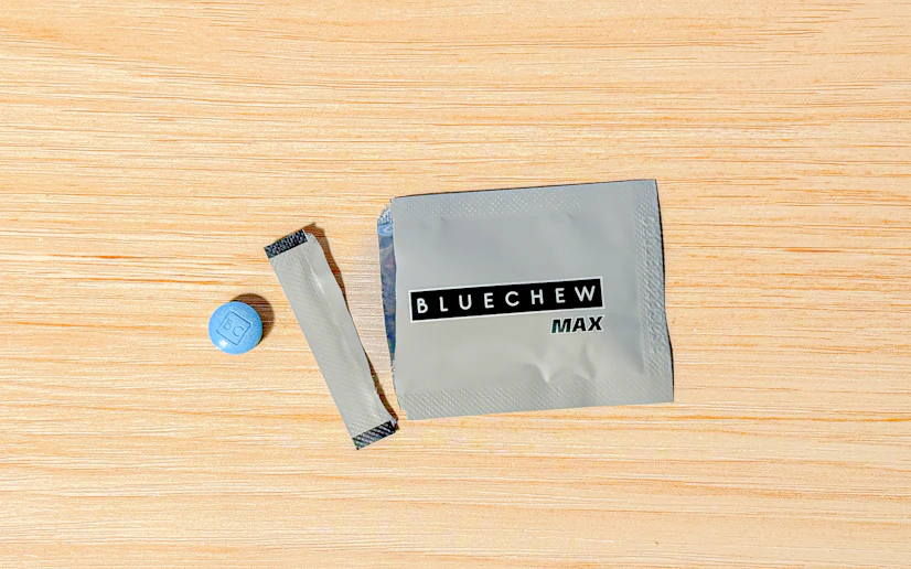 BlueChew Max packet torn open on a wood surface