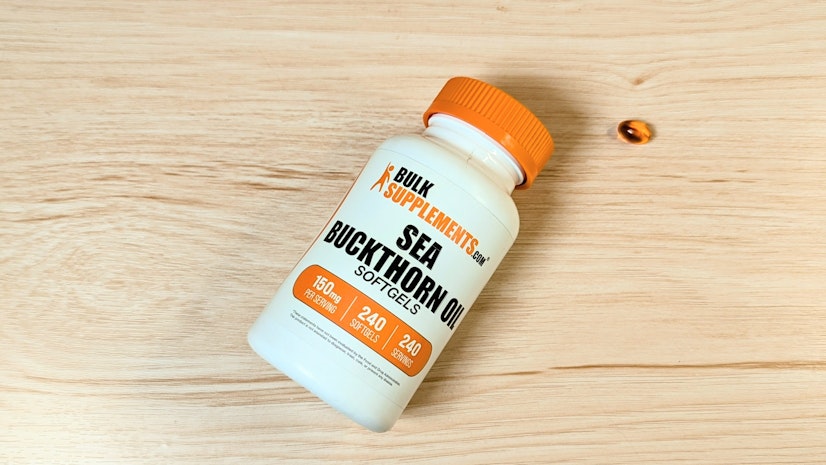 Bottle of Bulk Supplements Sea Buckthorn Berry Oil next to a one-softel serving.