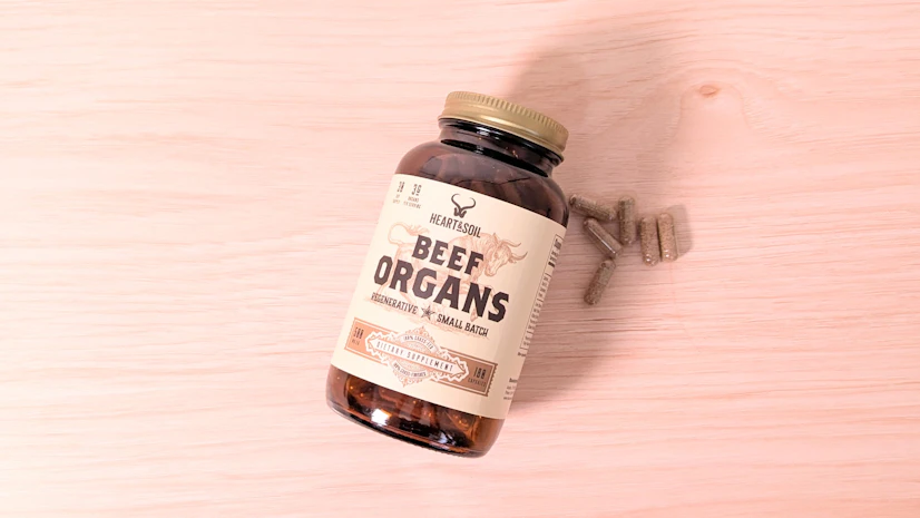 Heart & Soil Beef Organs, with a six-capsule serving, on a wood surface.