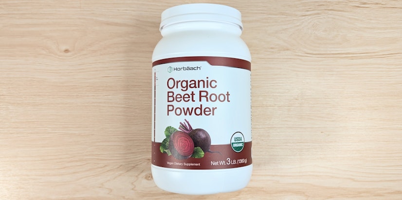 A larger container of Horbäach Organic Beet Root Powder on a wood surface.