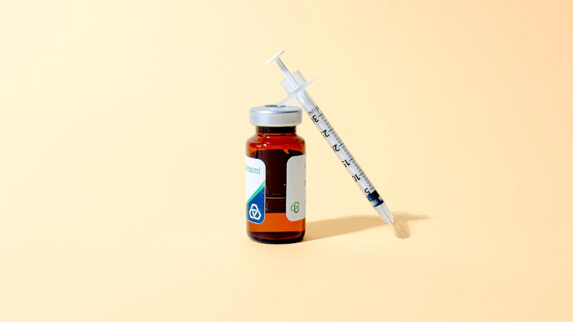 vial of LL-37 peptide and syringe on a yellow background.