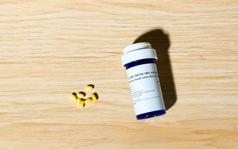 Rugiet Grower bottle and pills laid out on a wood surface