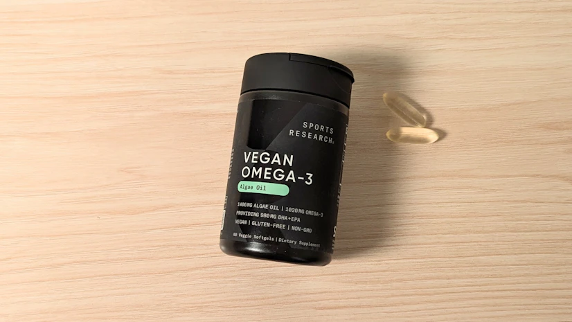 Sports Research Vegan Omega-3 on a wood surface.