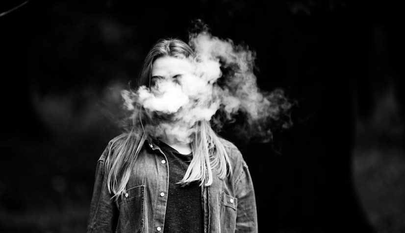 a black-and-white photo of a teenager vaping