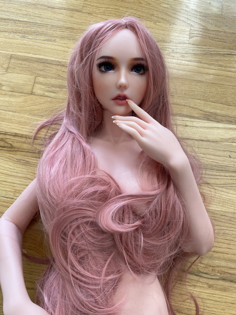 Unboxed realistic female sex doll with long pink hair